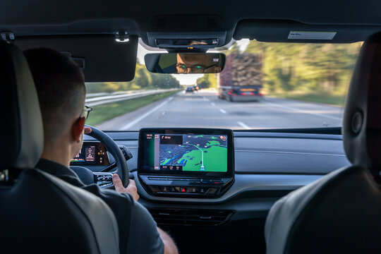 Man touching screen of a GPS navigation system in his car.