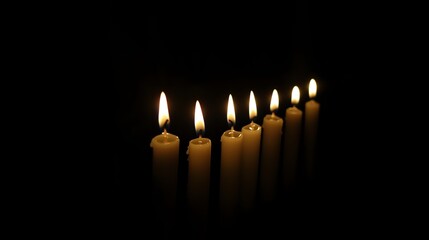 A serene display of lit candles casting gentle light in a dark setting, creating a calming and tranquil atmosphere for reflection.