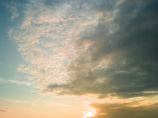 The rays of the sun breaking through the dramatic clouds in the evening or in the morning in the sunset or sunrise sky.