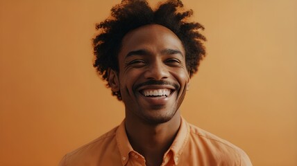 Obraz premium portrait of a an extremely happy black man with a light orange background