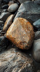Fototapeta premium A large, smooth, orange rock sits amongst a bed of smaller, grey stones.