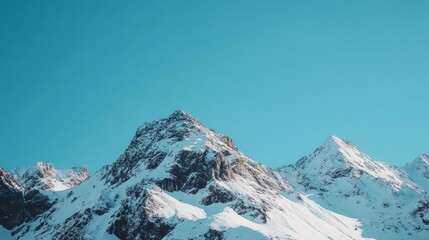 Naklejka premium Majestic snow-capped mountain peaks rise against a pristine blue sky, showcasing nature's grandeur and tranquility in a serene alpine landscape.