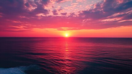 Obraz premium The sky is a beautiful shade of pink and orange, and the ocean is calm