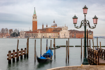 Winter view of gondola from San Marco square Italy with long exposure, illuminated lantern and church
