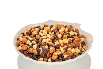 Nut mixture with dried berries on a white ceramic plate, macro, isolated on white background.
