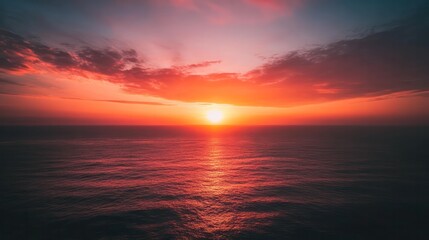 Obraz premium A beautiful sunset over the ocean with a bright orange sun