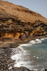 Scenic Amarilla Beach with Rocky Cliffs and Ocean Waves