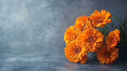 A bouquet of orange flowers is placed on a grey background