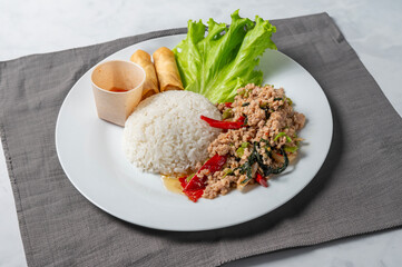 plate of stir fried pork isolated on white table and gray napkin , horizontal and close up