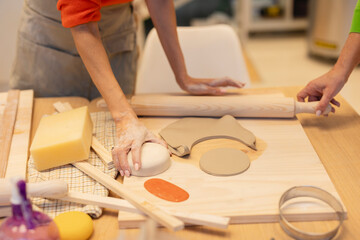 Hands Shaping Clay with Pottery Tools in a Studio