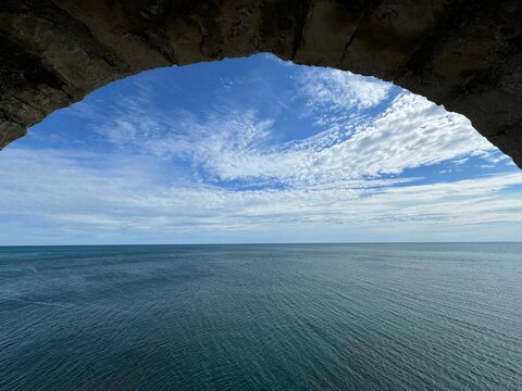 View on sea and sky through ancient fortress window.