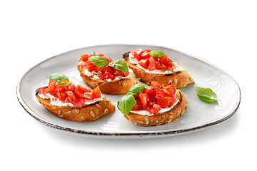 Plate of Cherry tomatoes and cream cheese bruschettas with fresh basil leaves. isolated on white background