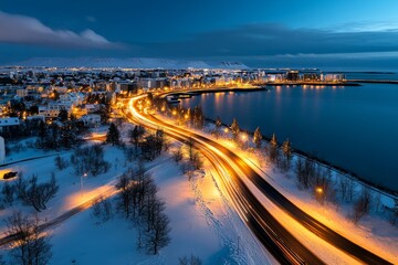 Fototapeta premium Aerial timelapse of Reykjavik at night, with the city lights glowing against the backdrop of a snowy landscape