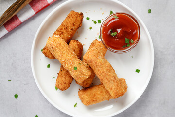 Breaded fried mozzarella cheese sticks with tomato dipping sauce. top view