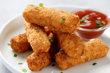 Breaded fried mozzarella cheese sticks with tomato dipping sauce.