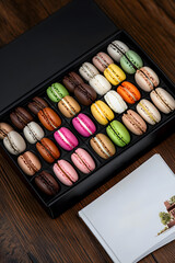 A box of macarons, different types and colors of French pastries. The packaging is sleek and modern, 