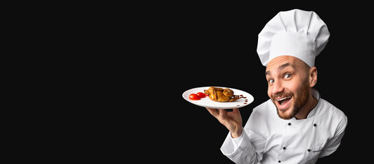 Bon Appetit. Excited Chef Holding Chicken Dish On Plate Standing On Black Studio Background. Panorama, Copy Space