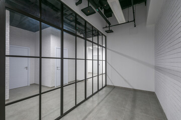 Obraz premium Modern design of office space in loft style with glass partitions. Working floor in the .corporate sector. Unfurnished.