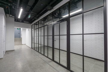 Loft-style office space with glass partitions. The working floor in the corporate office.