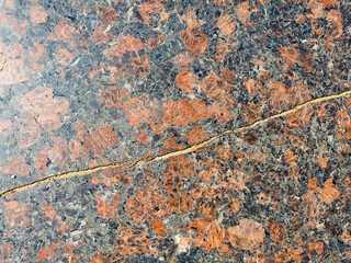 Cracked granite. The damaged old surface of a granite slab. © Binkontan