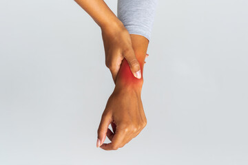 Cropped image of african woman suffering from rheumatism, massaging her wrist over grey background
