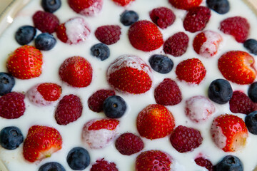 In a plate with freshly whipped cream juicy berries strawberries raspberries