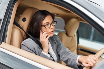 Business, woman and driving a car with phone call for communication, conversation or morning commute. Professional driver, person or talking on smartphone in vehicle for travel, contact or discussion