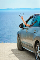 A happy girl from car at sea greece background