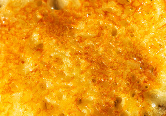 Rich, melted cheese glistens with a golden hue, inviting appetites. The bubbling surface hints at a comforting dish ready to be savored, perfect for sharing among friends.