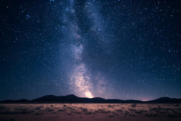 Night sky filled with twinkling stars and the Milky Way, above a calm desert landscape



