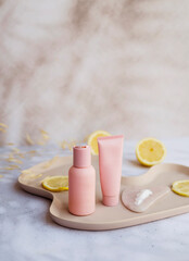 Vitamin C face cream and tonic  with lemon slices on shadows background 