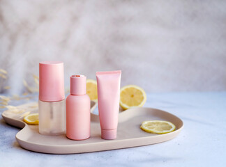 Vitamin C face cream and tonic  with lemon slices on shadows background 