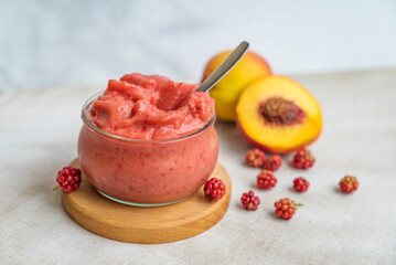 Homemade peach sorbet in glass on a shadows background 