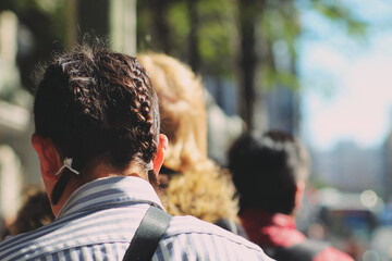 Pessoas de costas em movimento, caminhando na cidade. 