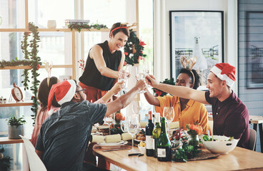 Christmas, champagne and cheers with people at dinner party for festive celebration, decoration or winter holiday. Toast, season and xmas eve gathering with friends for support, vacation or tradition