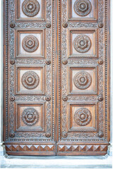 Detailed shot of the wooden door of the Cathedral Of Lucca (Duomo di San Martino) in Tuscany, Italy