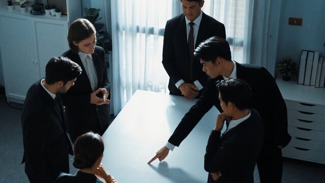 Top view of project manager looking at meeting table surrounded by diverse business people brainstorm and planning strategy. Group of smart people discussing and solve business problems. Directorate.