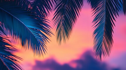 Blue tropical palm fronds swaying in the ocean breeze set against a sunset sky with pink and purple hues creating a beachside evening vibe