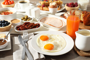 Different meals served for breakfast on wooden table