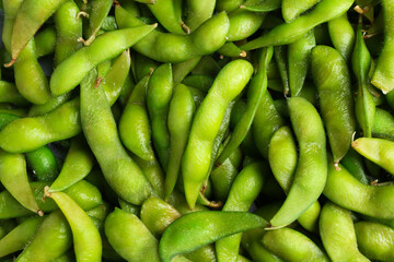 Fresh edamame pods as background, top view