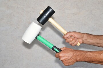 Rubber hammers in hands of a worker.