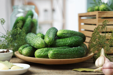 Fresh cucumbers, dill and spices on wooden table, closeup. Preparation for pickling