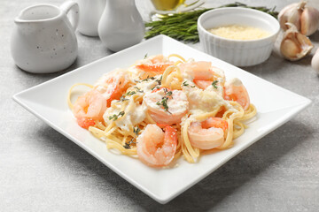 Delicious pasta with shrimps served on light table, closeup