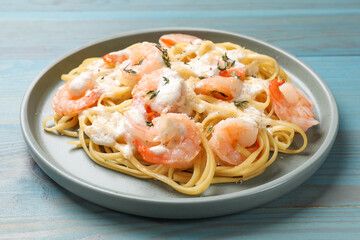 Delicious pasta with shrimps on blue wooden table, closeup