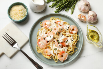 Delicious pasta with shrimps served on white table, flat lay