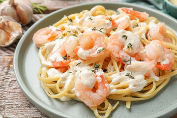 Delicious pasta with shrimps served on wooden table, closeup