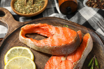 Tasty grilled salmon steaks, lemon and spices on table, closeup