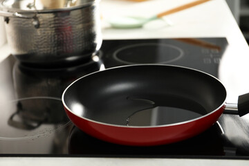 Frying pan with oil on cooktop in kitchen, closeup
