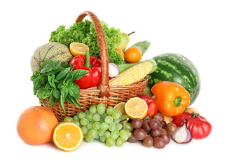 Different fresh fruits and vegetables in wicker basket isolated on white