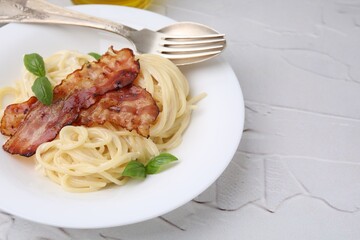 Delicious pasta Carbonara served on light textured table, closeup